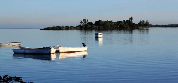 Barques de pêcheurs au lever du jour dans un lagon calme de l'île Maurice en juillet