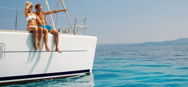 Couple assis à la proue d’un voilier sur le lagon turquoise de l’île Maurice